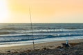 Fishing rod and beach chair on the beach at sunrise with birds flying by Royalty Free Stock Photo