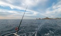 Fishing rod on charter fishing boat on the Sea of Cortes / Gulf of California viewing Lands End at Cabo San Lucas Baja Mexico Royalty Free Stock Photo
