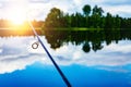 Fishing rod close-up with a beautiful sunrise on blue lake in Finland Royalty Free Stock Photo