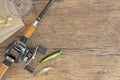 Fishing rod cork handle with reel and plastic fish bait lures have sharp metal hoop pace on old wood table for background Royalty Free Stock Photo