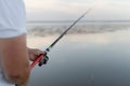 Fishing rod with a float in male hands. The man is a fisherman. River or estuary. Modern fishing tackle. I& x27;m waiting for Royalty Free Stock Photo