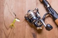 Fishing rod and lure on wood surface