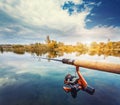 Fishing rod near beautiful pond with cloudly sky