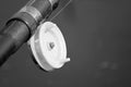 Fishing rod with a reel close-up, black and white photo Royalty Free Stock Photo