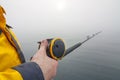 Fishing rod with a reel in hand Royalty Free Stock Photo