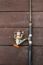 Fishing rod reel on the wooden board Royalty Free Stock Photo