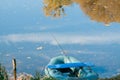 Fishing rod in a rubber boat, small lake, trees and sky reflection on still water surface, sunny autumn morning Royalty Free Stock Photo