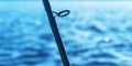 Fishing rod spinning rod with the line close-up. Fishing rod. Fishing tackle. Fishing spinning reel over blue ocean water