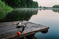 Fishing rod, spinning reel on the background pier river bank. Sunrise. Fog against the backdrop of lake. Misty morning. wild Royalty Free Stock Photo