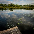 Fishing rod, spinning reel on the background pier river bank. Sunrise. Fog against the backdrop of lake. Misty morning Royalty Free Stock Photo