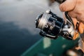 Fishing rod with a spinning reel in the hands of a fisherman. Royalty Free Stock Photo