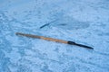 Fishing rod waiting for a fish nibble in a frozen river hole, ice auger lie, human tracks in snow, winter forest sunset, ecology Royalty Free Stock Photo