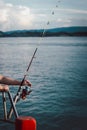 Fishing rod wheel closeup, man fishing from the boat in the sea Royalty Free Stock Photo