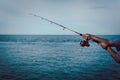 Fishing rod wheel closeup, man fishing from the boat in the sea Royalty Free Stock Photo
