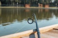 Fishing rod on wood bridge coast over lake in summer, closeup Royalty Free Stock Photo