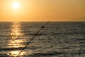 Fishing rodes  pointing at sunset on Newport Beach pier Royalty Free Stock Photo