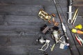 Fishing rods and reels, fishing tackle on black wooden background.