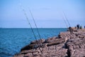 Fishing rods and reels on jetty in Port Aransas, TX at the Gulf of Mexico