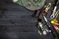 Fishing rods and reels, fishing tackle on black wooden background.