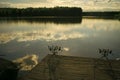 Fishing rods on wooden pier on pond Royalty Free Stock Photo