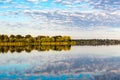 Fishing on the shore of a lake near the village in the early autumn. Reflection of clouds on the water surface of the river. The b Royalty Free Stock Photo