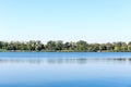 Fishing on the shore of a lake near the village in the early autumn. Reflection of clouds on the water surface of the river. The b Royalty Free Stock Photo