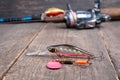 Fishing spinning reel and fishing lures on wooden table Royalty Free Stock Photo