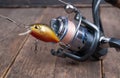 Fishing spinning reel and fishing lures on wooden table Royalty Free Stock Photo