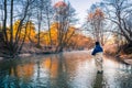 Autumn fishing. Fisherman in professional wear standing in creek