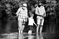 Fishing. Summer weekend. Father and son fishing. Fishing in river. Three generations ages: grandfather, father and young Royalty Free Stock Photo