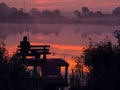 Fishing by the sunrise in the lake. Royalty Free Stock Photo