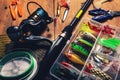 Fishing tackle - spinning rod with box of lures and angling equipment on wooden table Royalty Free Stock Photo