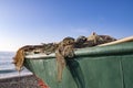 Fishing tackle on the stern of the ship. Fishermans green boat on the seashore. Royalty Free Stock Photo