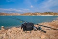 Fishing tackles lie on a shore of lake.