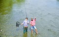 Fishing team. Happy fisherman with fishing rod and net. Hobby and sport activity. Male friendship. Father and son