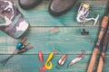 Fishing theme. background from fishing rods with fishing tackles, rubber boots, camouflage cap and fishing buoy on green wooden ba