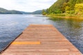 Fishing tourism relax concept. Beautiful forest lake or river on sunny summer day and old rustic wooden dock or pier. Fishing Royalty Free Stock Photo