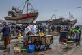 A fishing trawler sits in dry dock as a fish monger sells fish at Essaouira in Morocco.