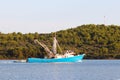 The fishing vessel for squid extraction returns in the early morning sailing past the green shore. Catch of cephalopods in the Adr Royalty Free Stock Photo