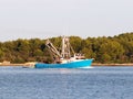 The fishing vessel for squid extraction returns in the early morning sailing past the green shore. Catch of cephalopods in the Adr Royalty Free Stock Photo