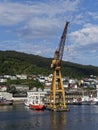 Fishing Vessels moored beside a large Yellow Shore Crane at the Fishing Port in Bergen,