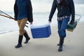 Fishing, walking and men with cooler on beach together with tackle box, water and holiday. Ocean, fisherman and feet of Royalty Free Stock Photo