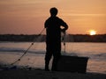 A Fishman polling out his net during sunset Royalty Free Stock Photo