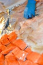 A fishmonger\'s stall with the hands of a person doing the merchandising