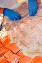A fishmonger\'s stall with the hands of a person doing the merchandising
