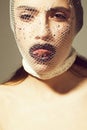 Fishnet stocking on head of girl showing tongue, black lips Royalty Free Stock Photo