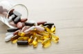 Fishoil capsules and Multivitamin supplements out of the small glass on the wooden table Royalty Free Stock Photo