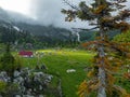 The fisht shelter is illuminated by a sunbeam in cloudy weather. Tourist camp filled with tents, top view. Tourist route no. 30