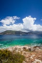 Fiskardo town, crystal clear transparent blue turquoise teal Mediterranean sea water. White yacht in open sea at anchor Royalty Free Stock Photo