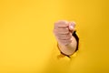 Fist broke yellow paper wall Royalty Free Stock Photo